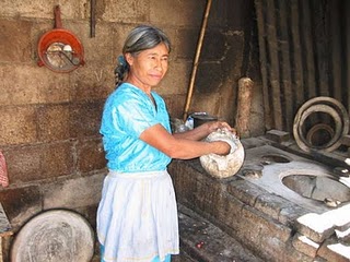 Se ve a una señora de rasgos mayas trabajando con las manos en un taller.